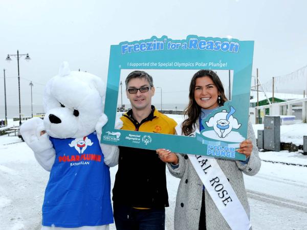two people and polar bear mascot smile to camera