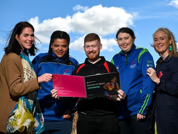 four women and a man read the Women in Sport action plan