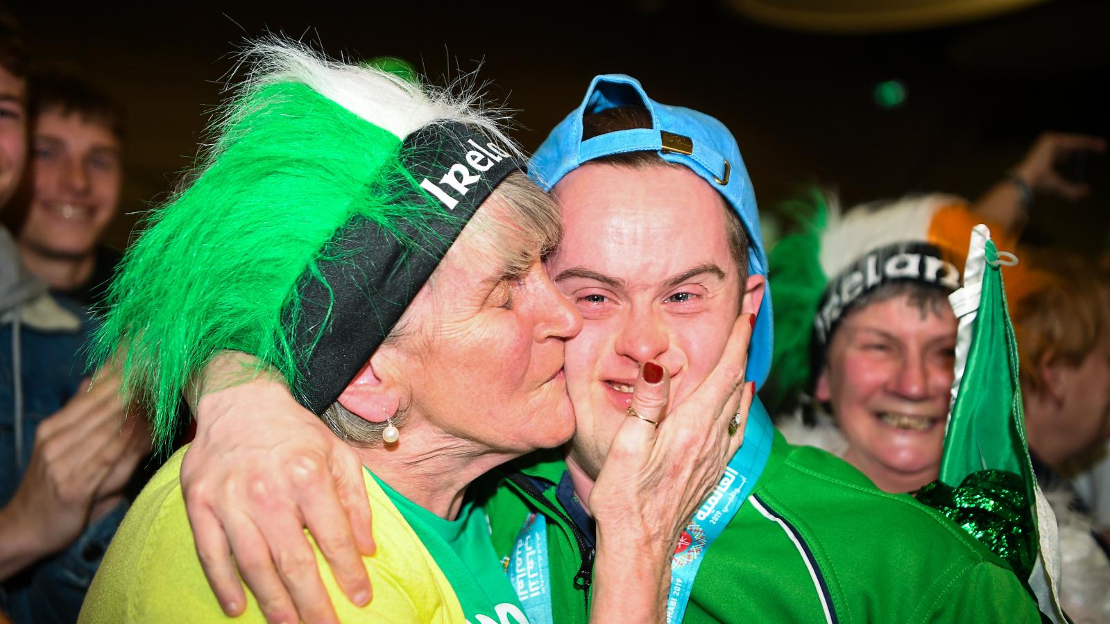 Mother kissing Special Olympics athlete on cheek