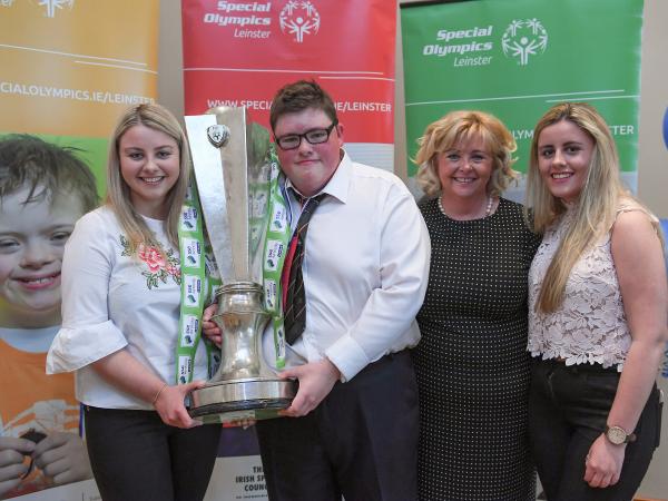 Athletes and coaches with trophy