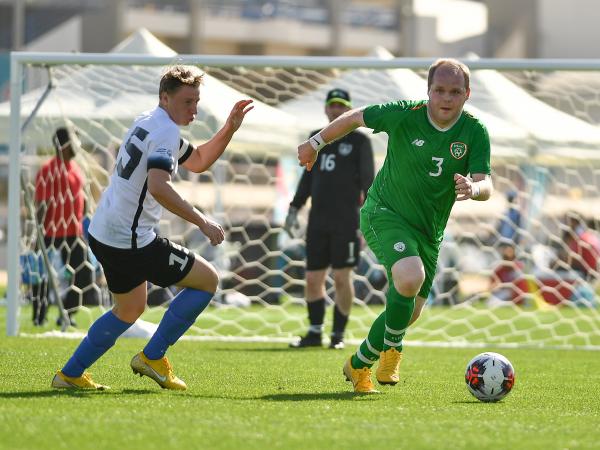 Football player dribbling ball away from opponent