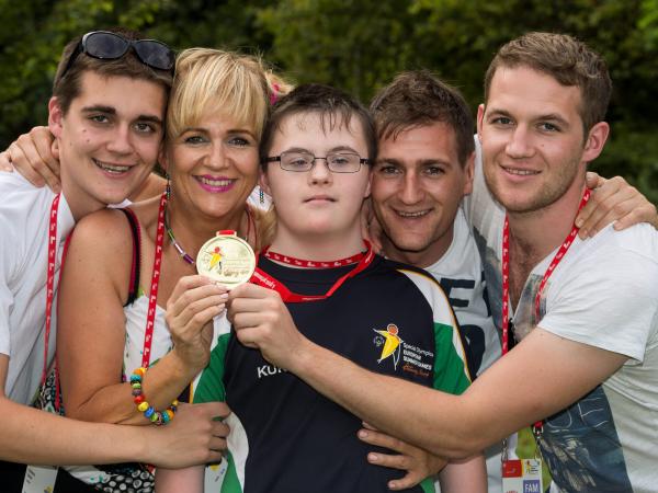 Athlete with family holding up medal