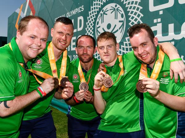 Members of Special Olympics Ireland team holding up medals in celebration