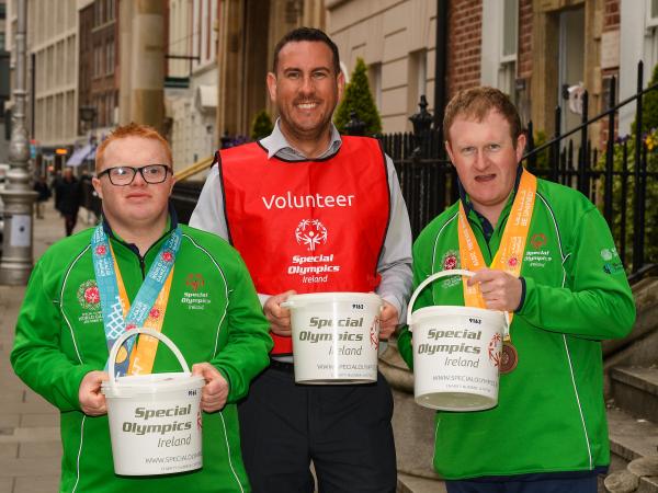 Athletes and volunteers helping shake a bucket on Collection Day