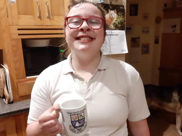 athlete drinking tea from  branded mug