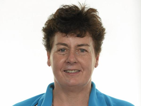 Woman in blue and white tshirt smiles to camera