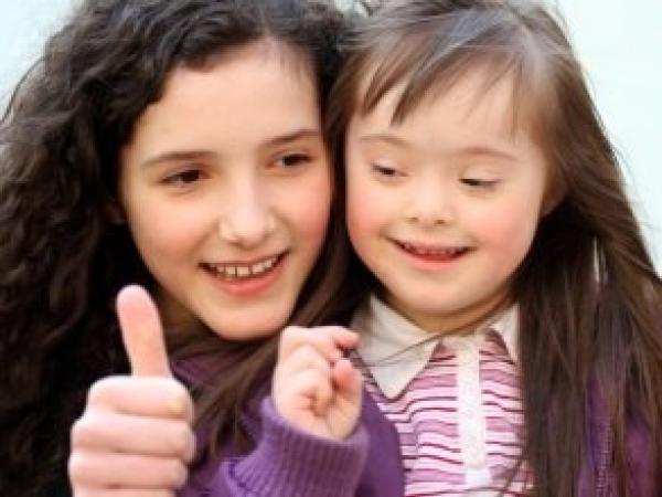 two children give thumbs up to camera
