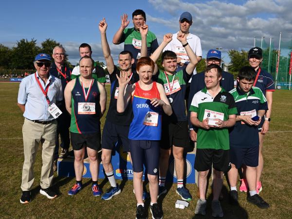 This image shows 71st Cork City Sports International Athletics Meet Special Olympics Ireland Munster. Smiling showing off their medals, some having hands in the air as a celebration.