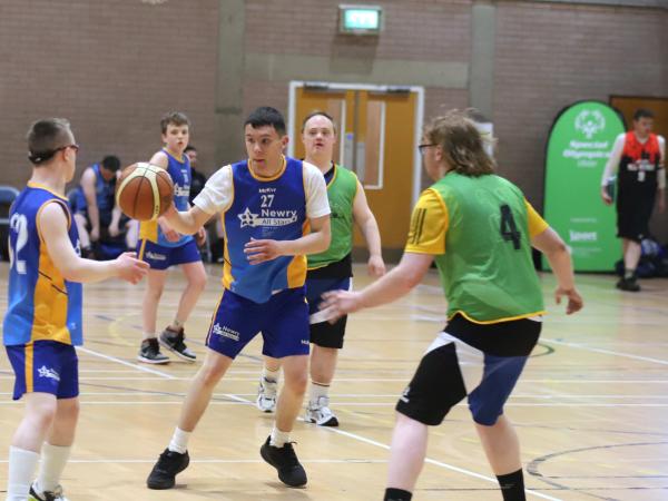 This image shows Athletes playing a basketball match together. Action shot