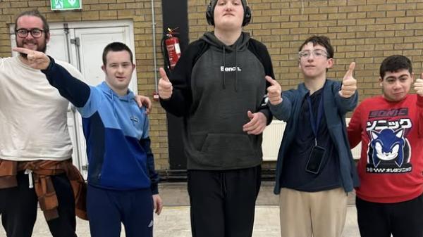 This image shows a team photo with  all thumbs up - Outside leisure centre.