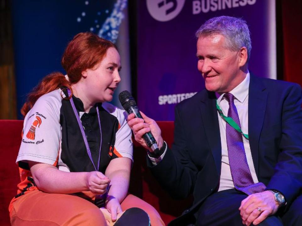 This image shows the 2026 Sport for Business event "Sporting Year Ahead". It features host Rob Hartnett interviewing a Special Olympics Ireland athlete .