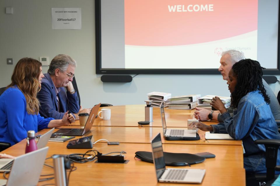 Representatives from the Golisano Foundation meeting around a conference table during a presentation at the Special Olympics Ireland office.
