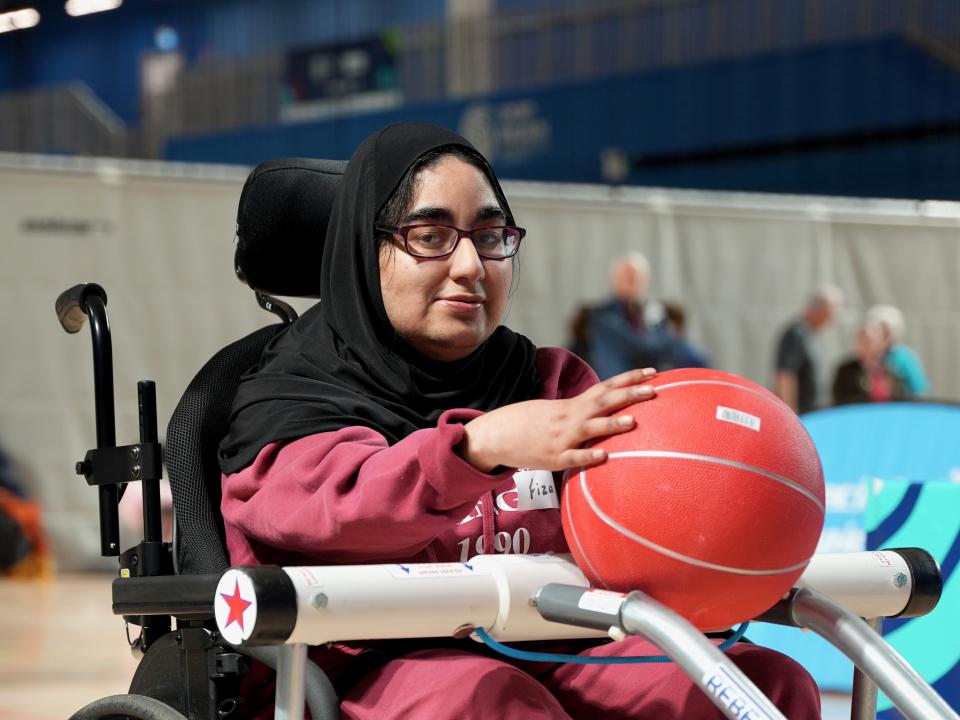 This image shows a female Motor Activities Training Program athlete performing an activity with a basketball.