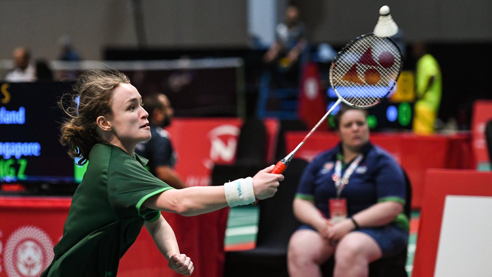 Girl aiming for shuttlecock with racquet