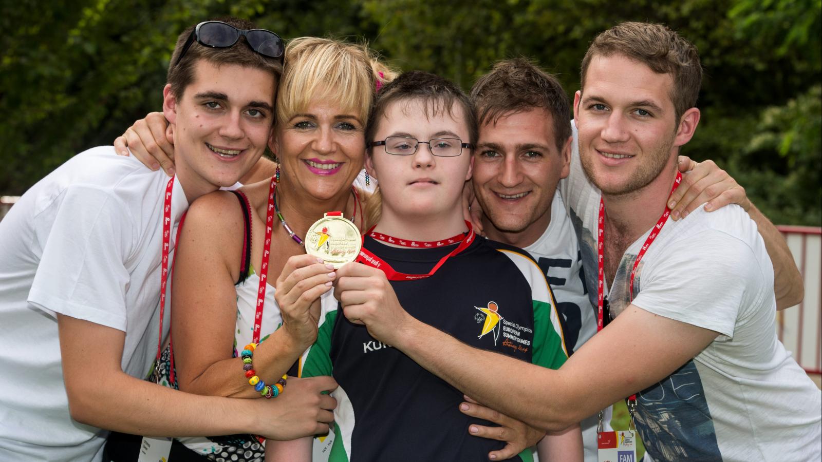 Athlete with family holding up medal