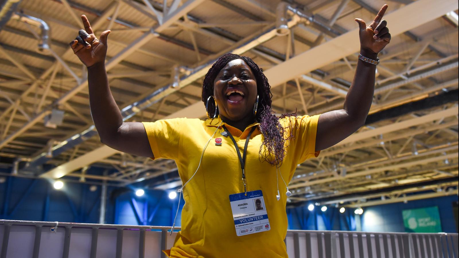 Smiling and happy volunteer lady with arms in air