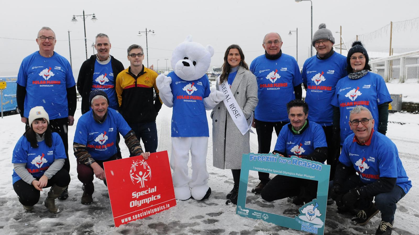 Group of people stand in the snow with polar bear costume